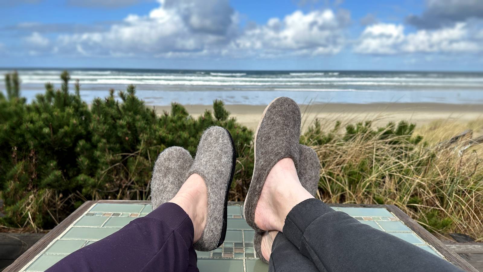 Man and woman wearing nootkas wool slippers at the beach
