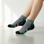 Gray socks with black toes and green accents worn by a person on a light background